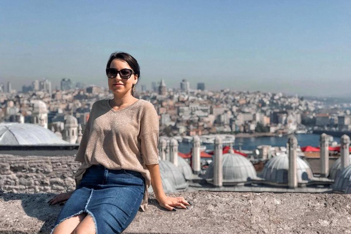 žena sedící na římse a dívající se na město