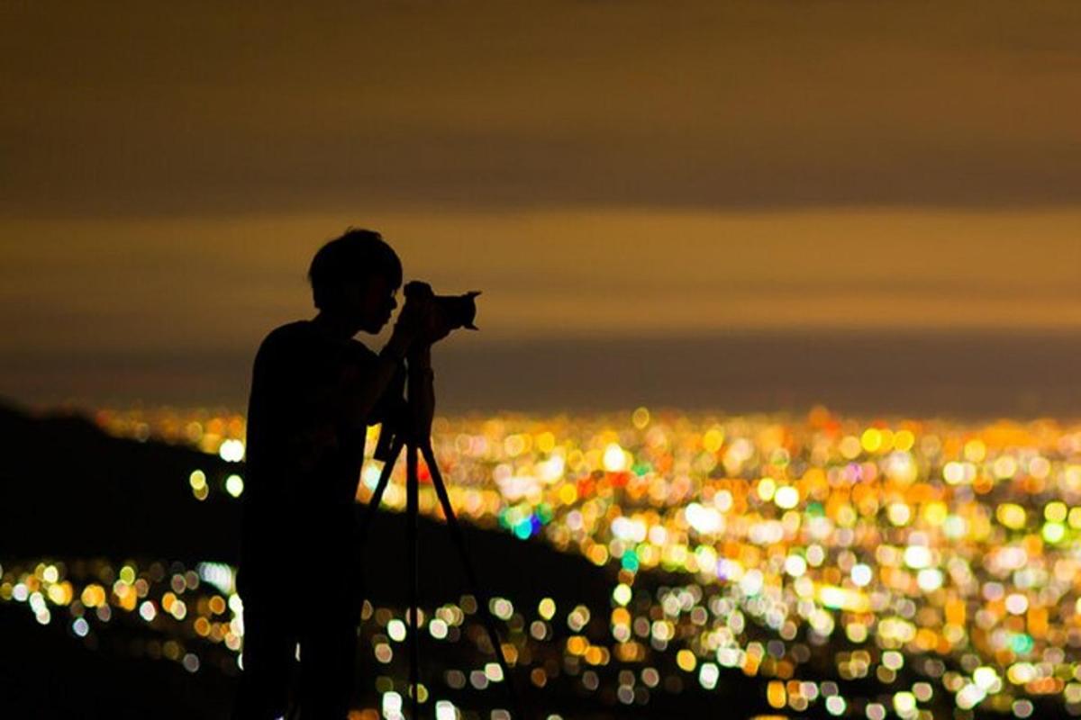 moški s fotoaparatom fotografira mesto