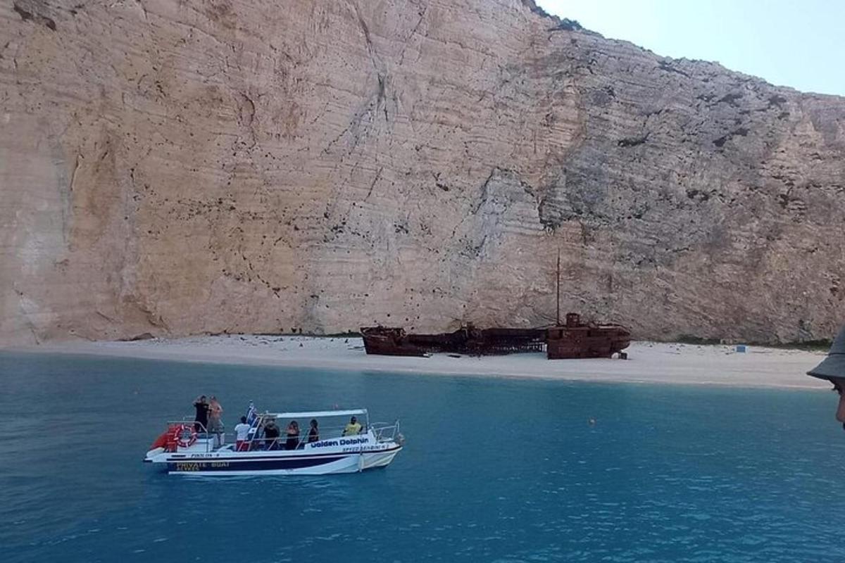 a boat in the water next to a mountain
