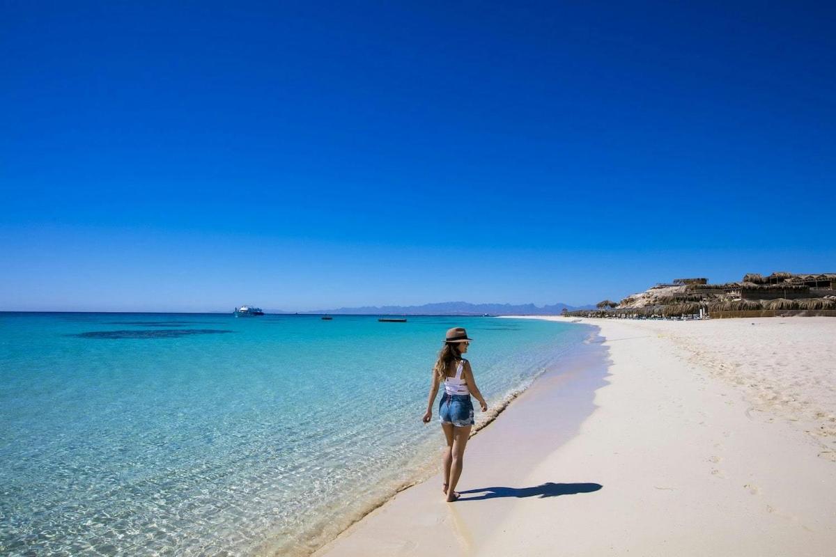 una dona caminant per la platja