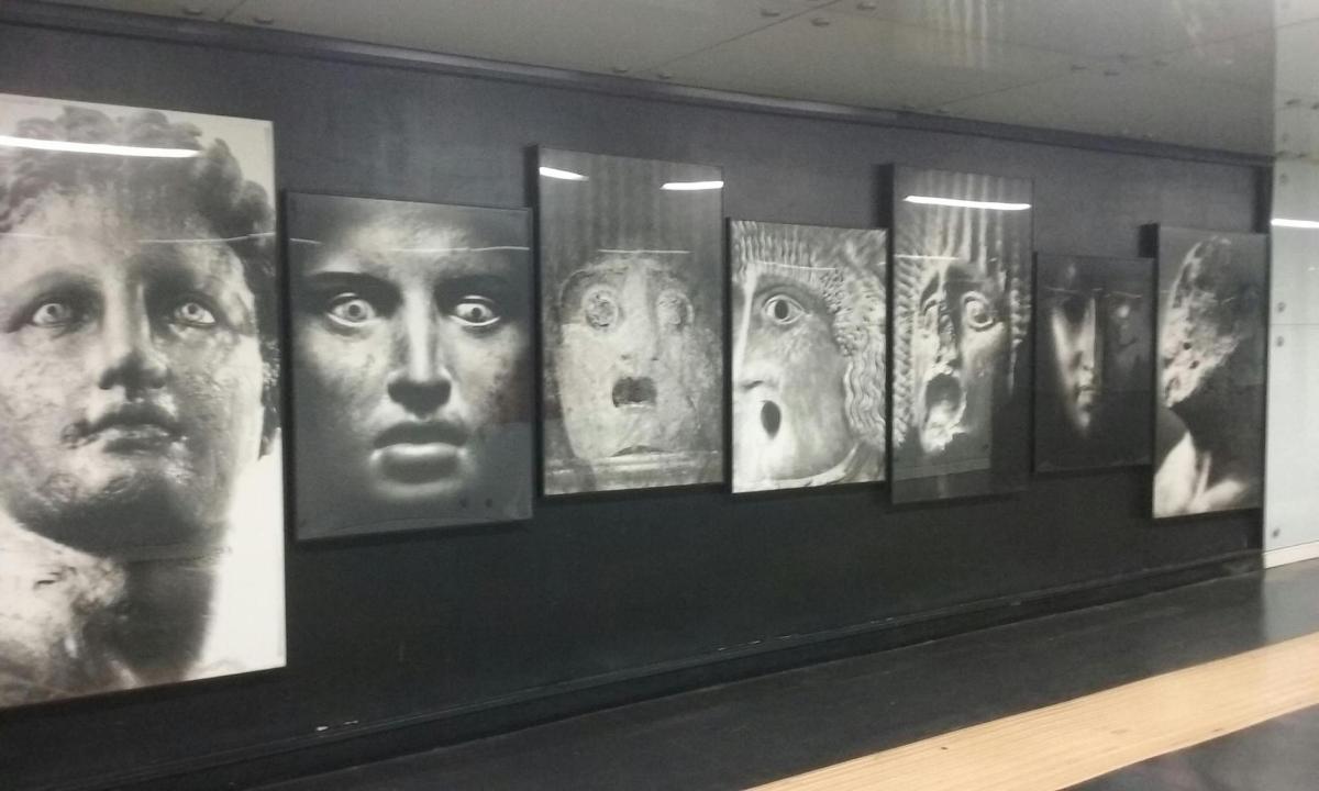 a display of photographs of faces on a wall