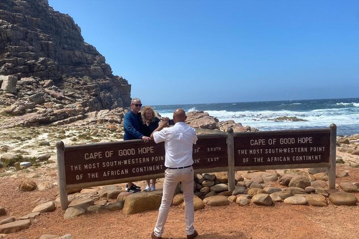 um homem parado ao lado de uma placa na praia