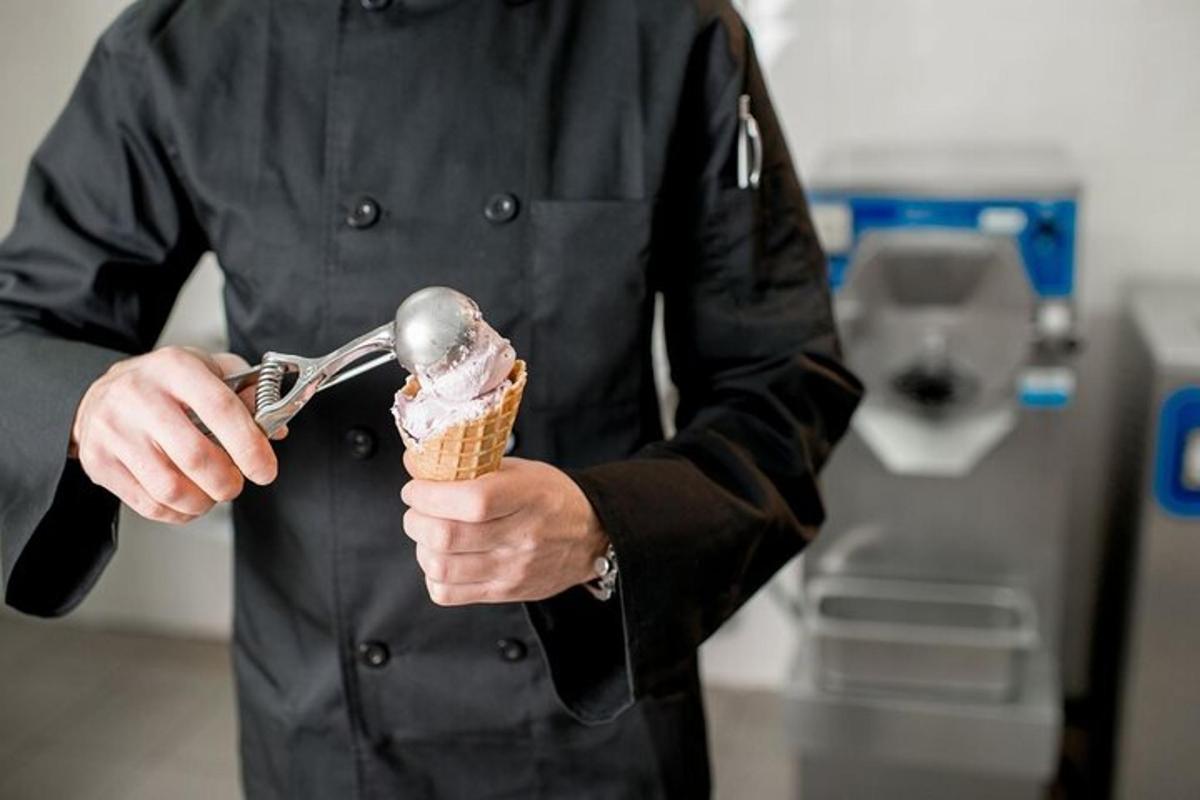 a man holding an ice cream cone with a spoon