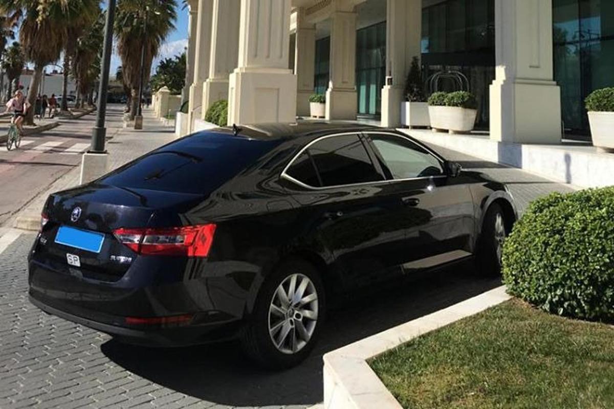 um carro preto estacionado em frente a um prédio