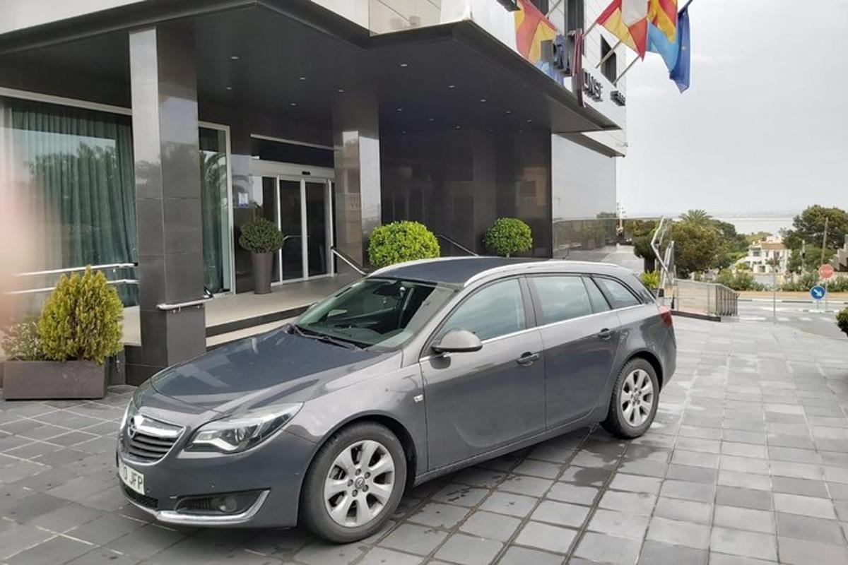 um carro cinza estacionado em frente a um prédio