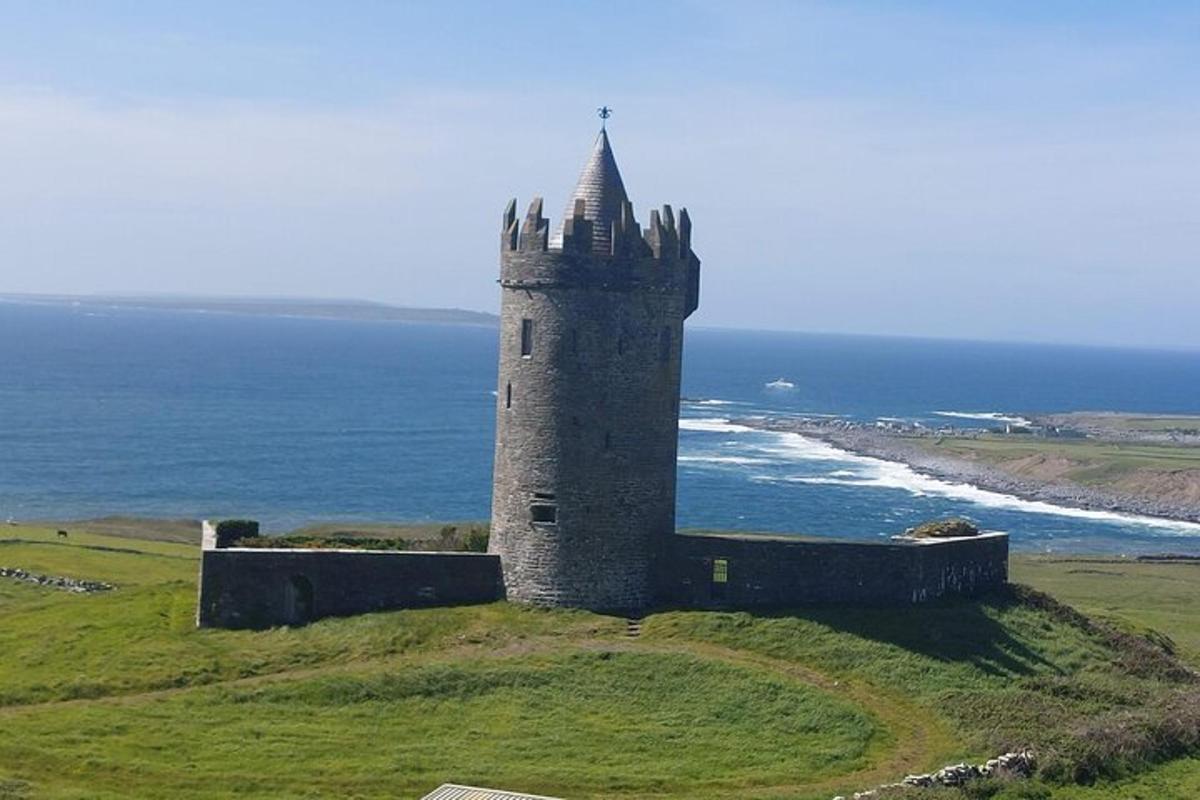 an old castle on top of a hill near the ocean