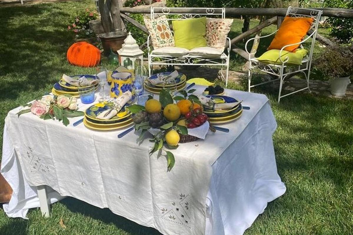 Una mesa blanca con platos y fruta encima.