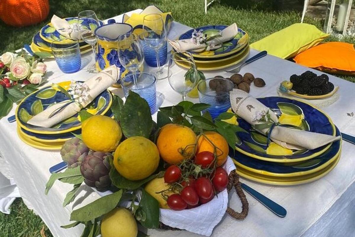 Una mesa con un montón de frutas y platos encima.