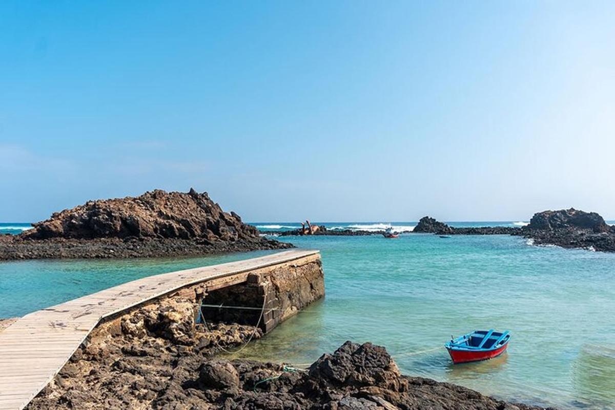 a small boat in the water next to a pier