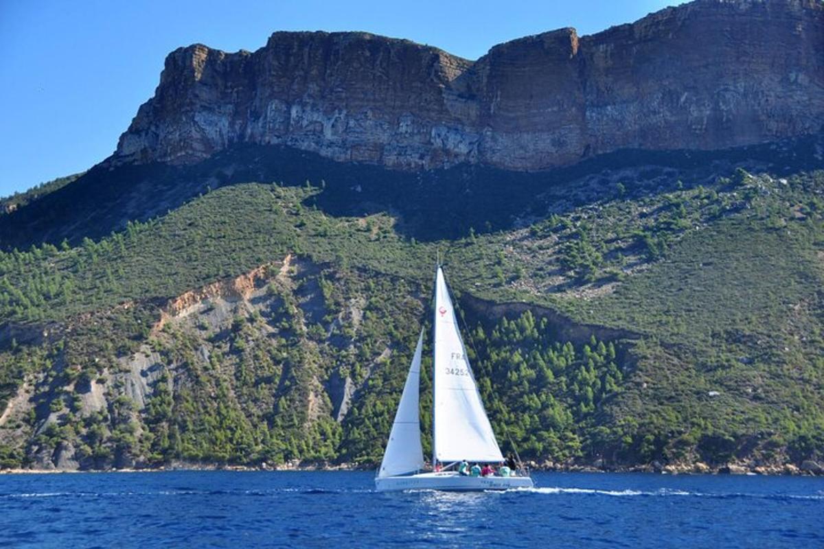 una barca a vela sull'acqua di fronte a una montagna
