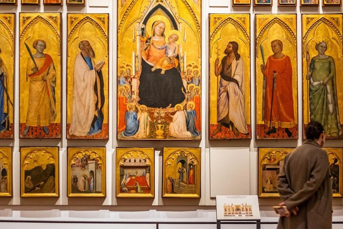 en mann går forbi en vegg med malerier i en katedral