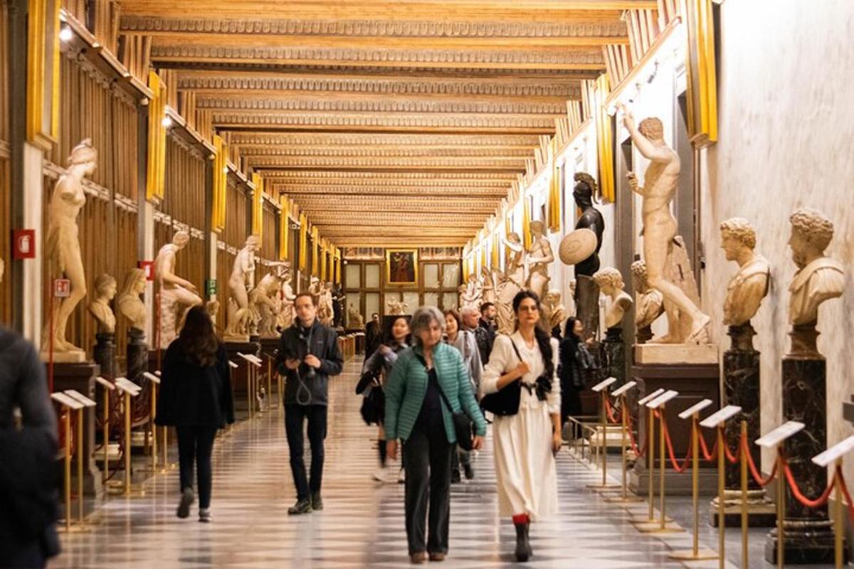 en gruppe mennesker som går gjennom et museum med statuer