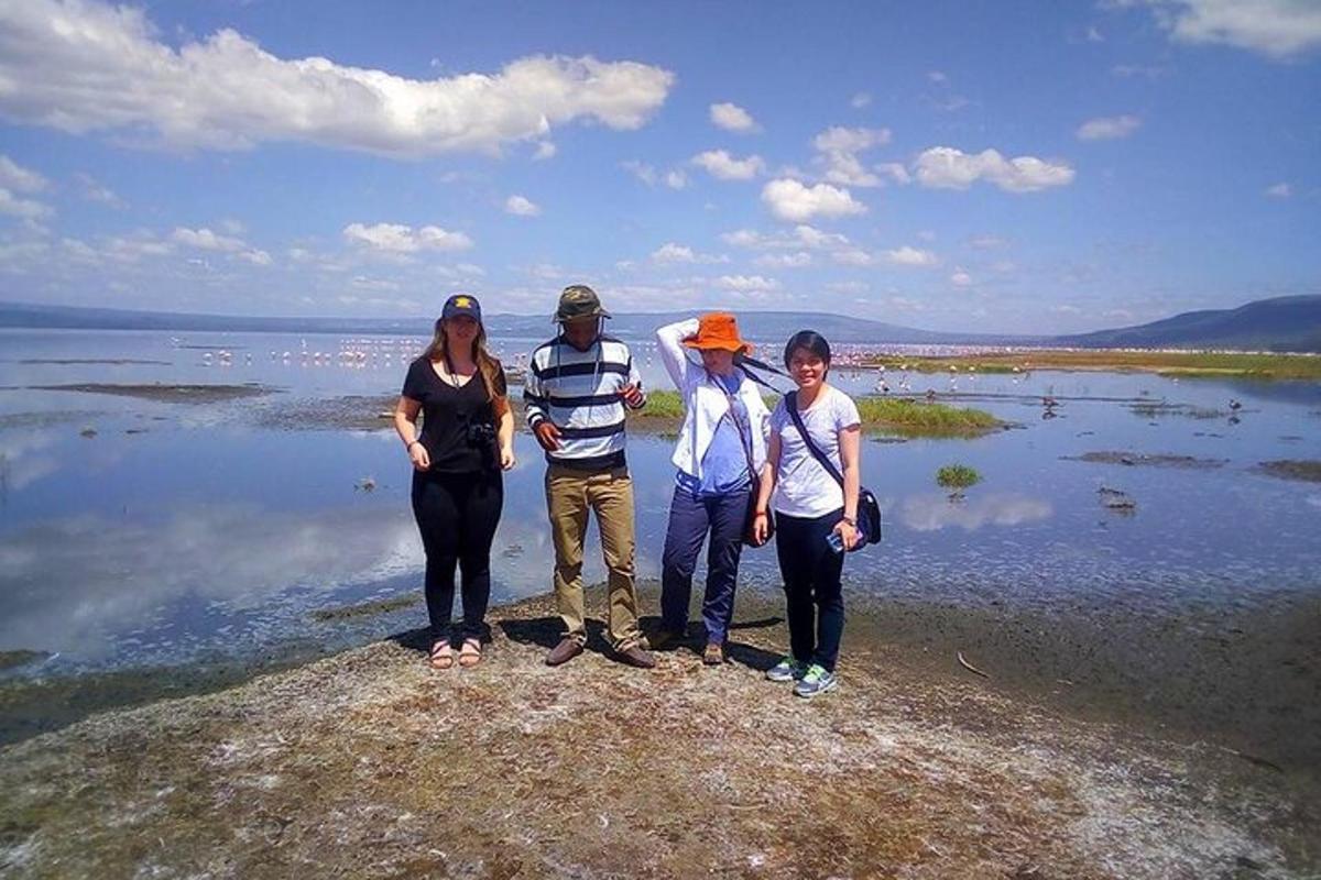 un grup de oameni care stau pe o stâncă lângă apă