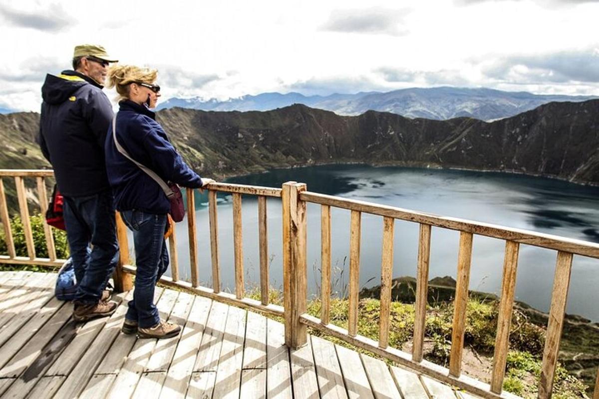 two people standing on a deck overlooking a lake