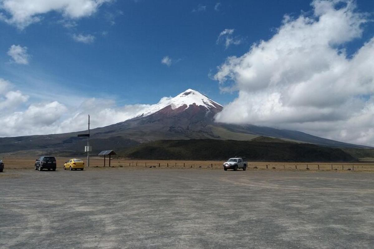 a mountain with cars parked in front of a parking lot
