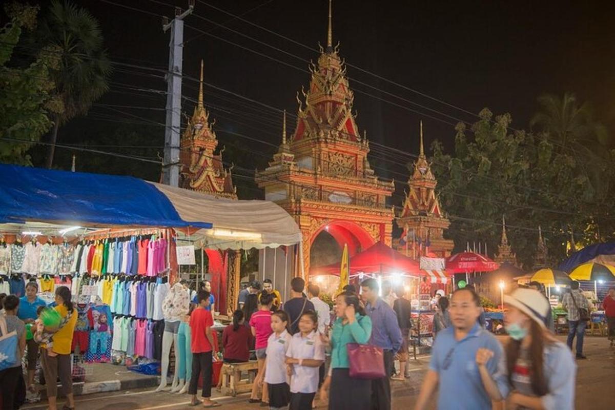 a crowd of people walking around a market at night