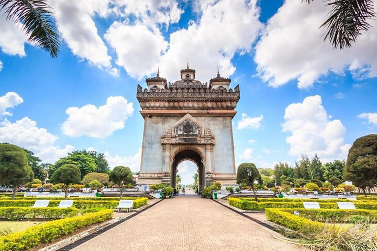 an arch in a park with trees and bushes