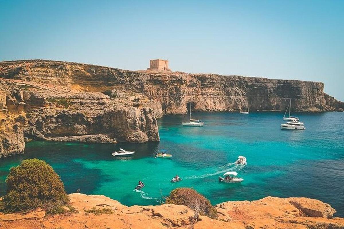 a group of boats in the water near a cliff
