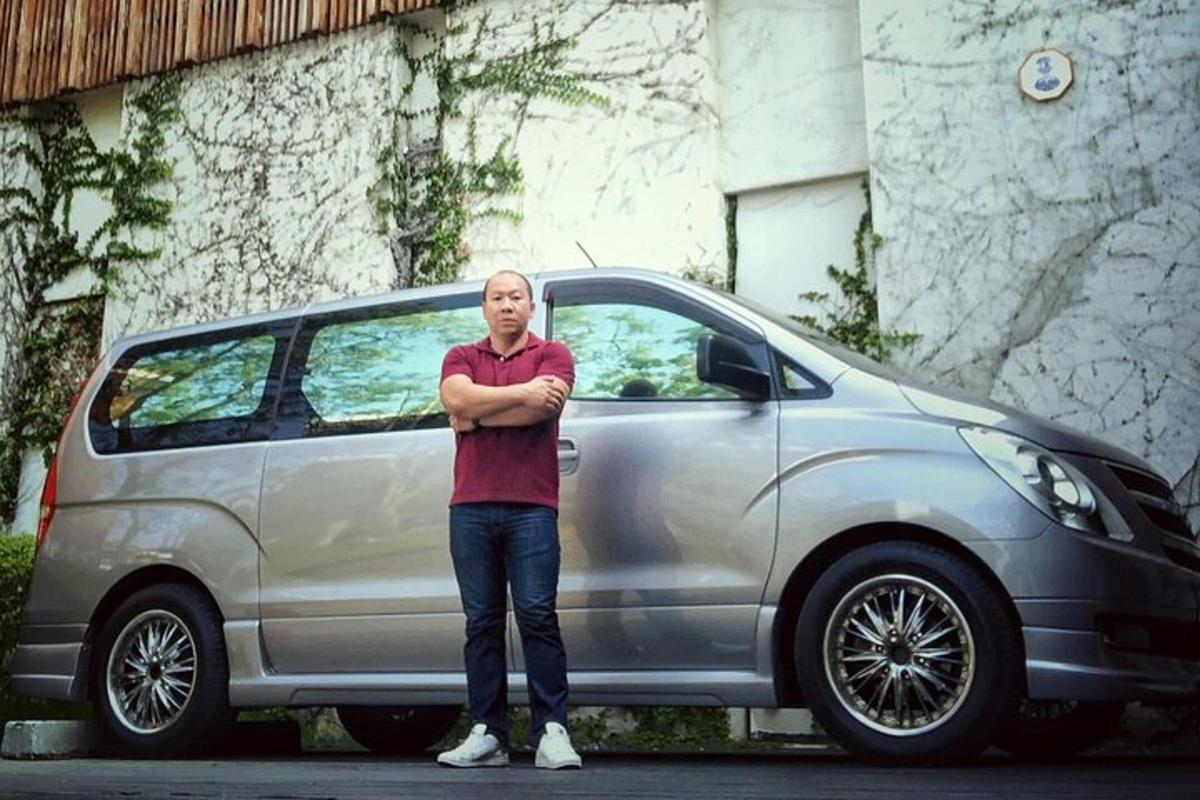 mees seisab hõbedase auto ees