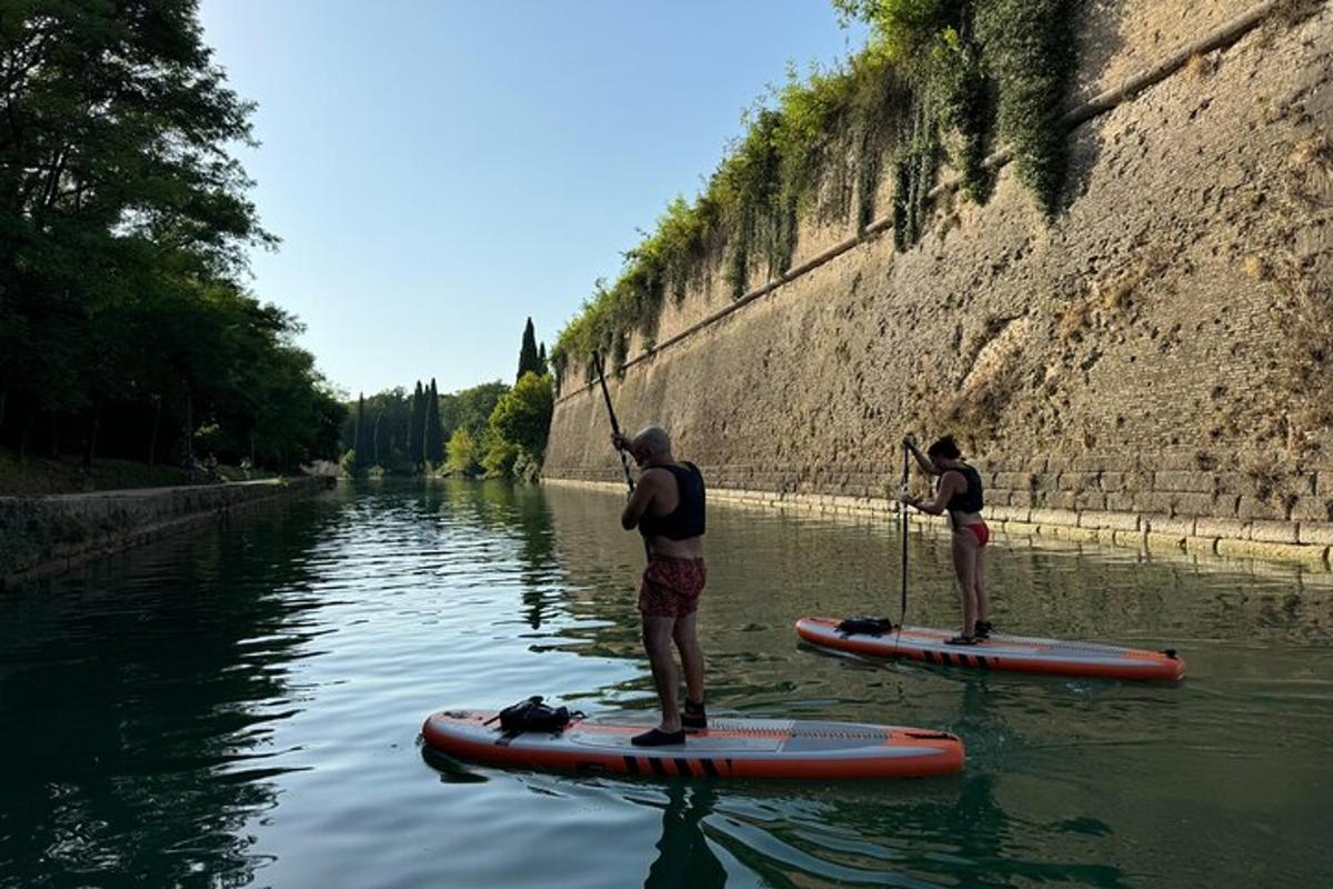twee mensen staan op paddleboards in het water