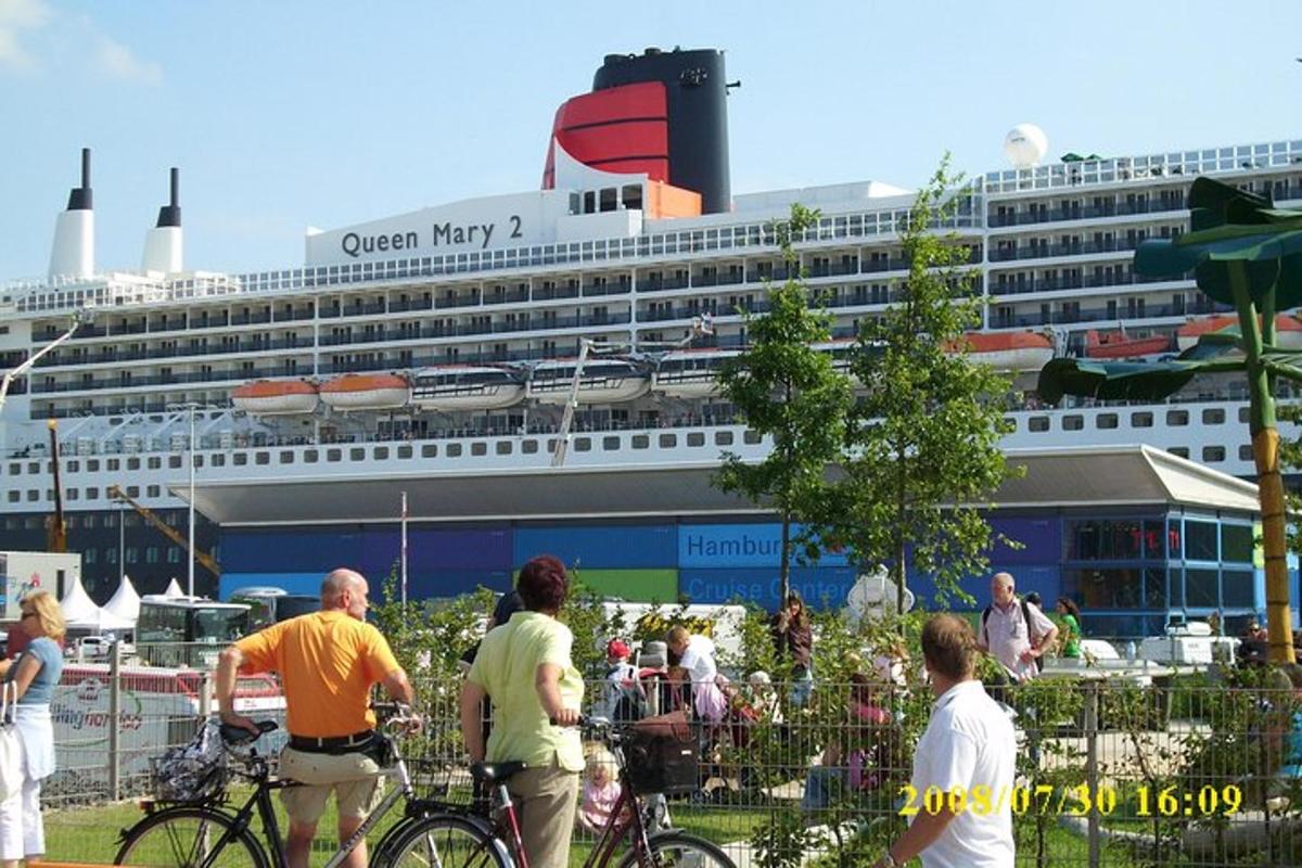 eine Gruppe von Menschen steht in der Nähe eines Kreuzfahrtschiffes
