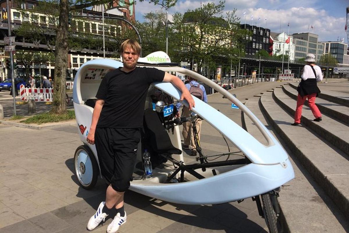 ein Mann steht neben einem Kleinwagen