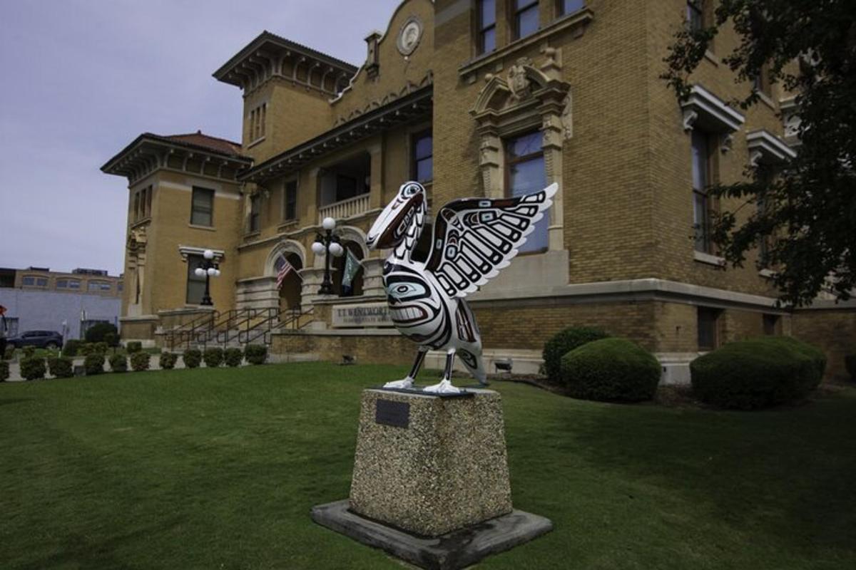 a statue of a bird in front of a building