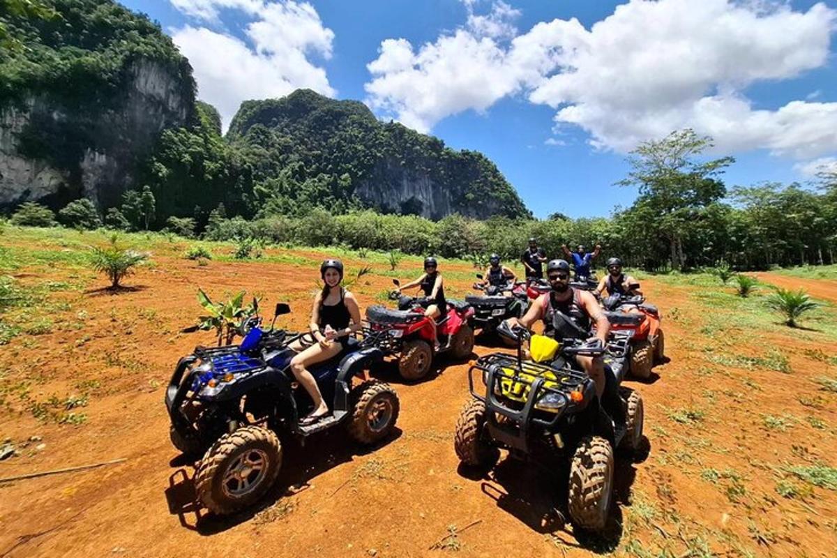 Un grupo de personas conduciendo vehículos todo terreno por un camino de tierra.