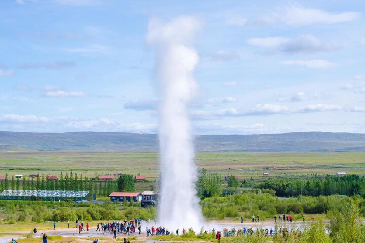 una folla di persone in piedi attorno a un geyser