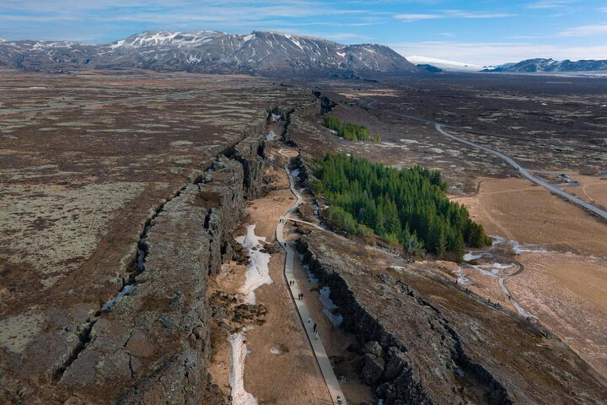 Una vista aérea de un río en un campo con montañas.