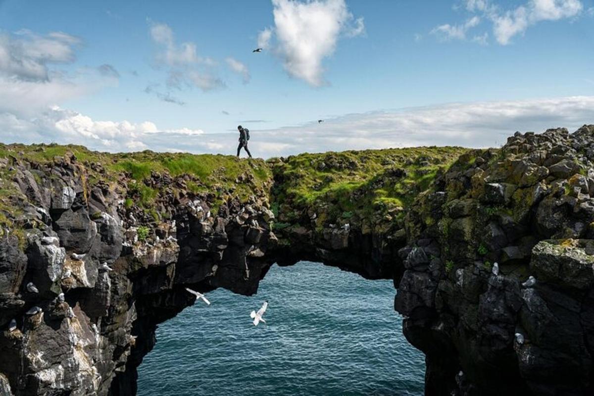 a man walking across a bridge over the water