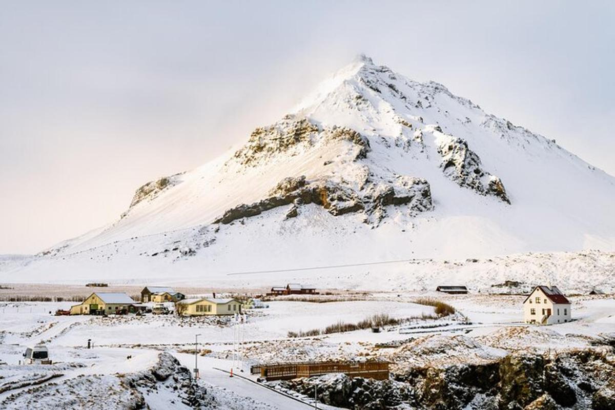 a snow covered mountain with a village in front of it