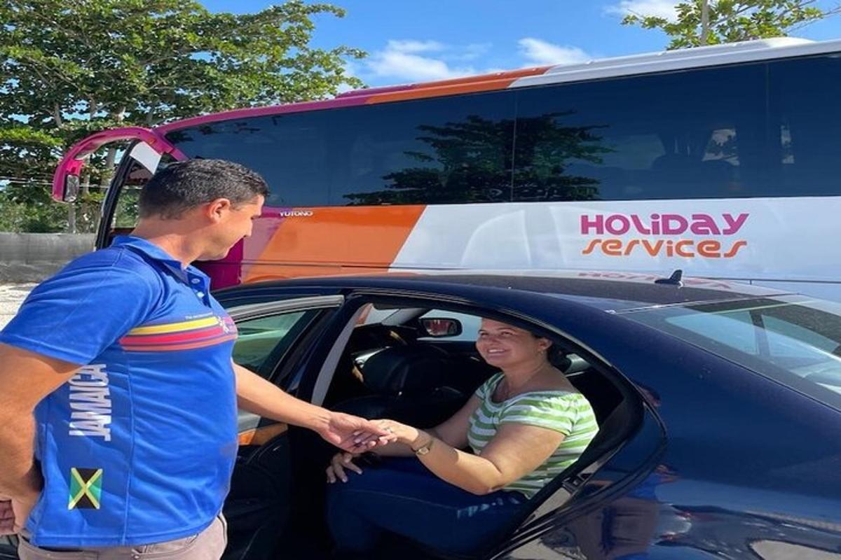 a man shaking hands with a woman inside of a car