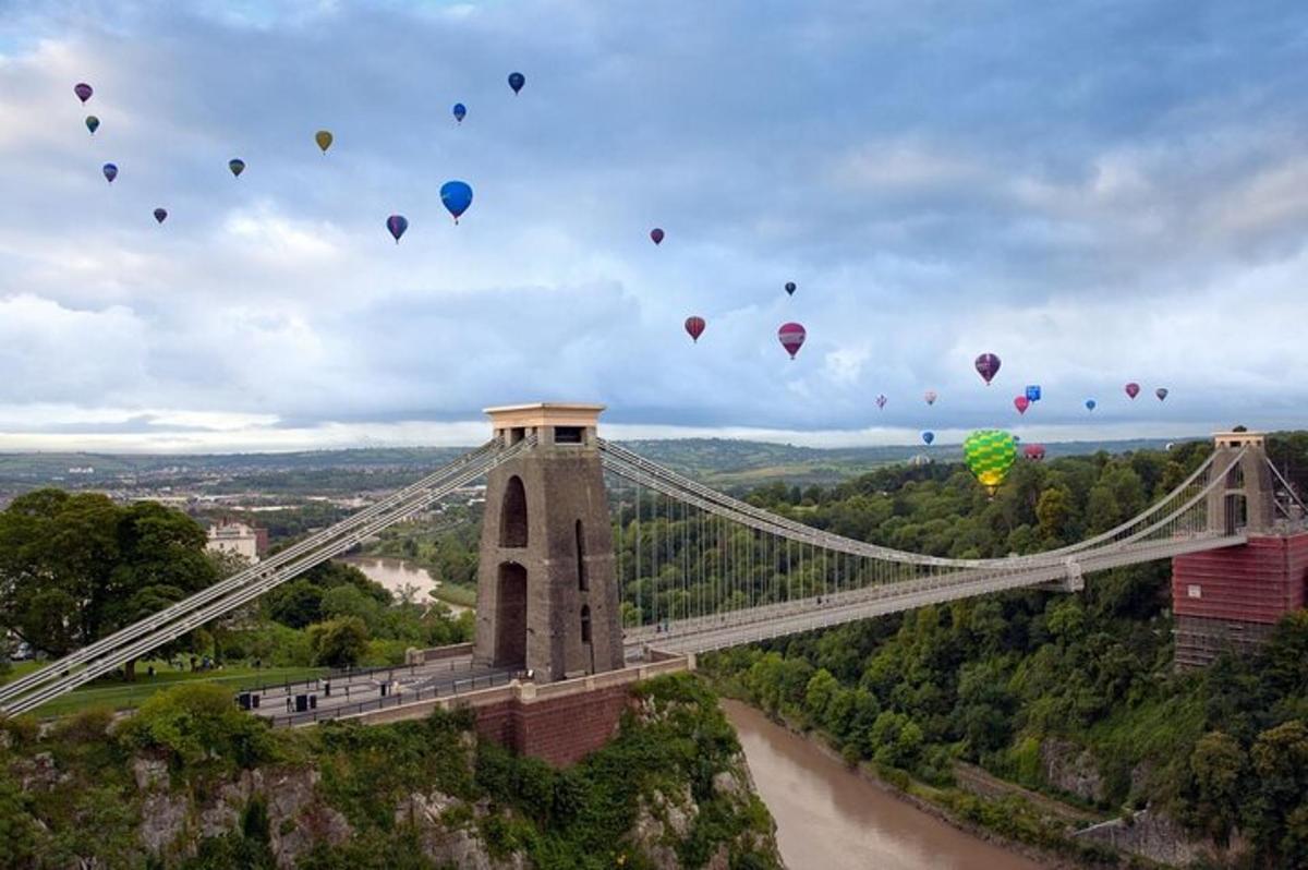 a group of hot air balloons flying over a bridge