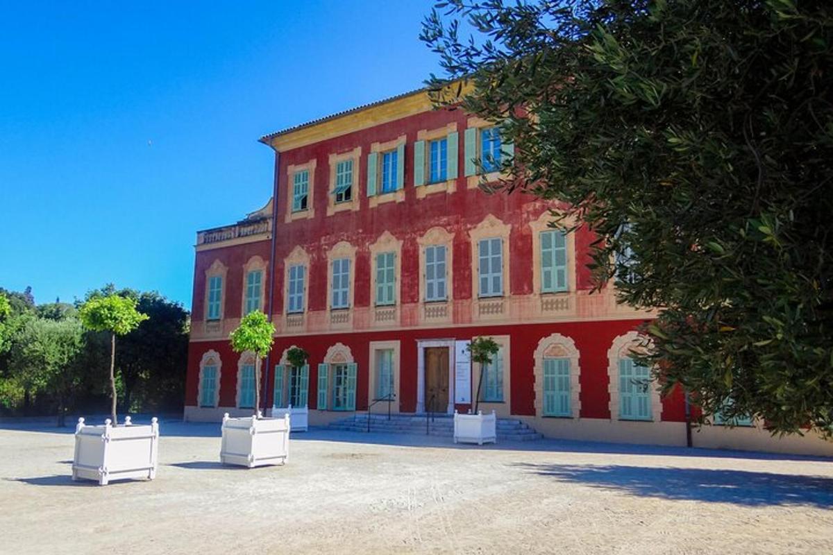 un grande edificio rosso con due alberi di fronte