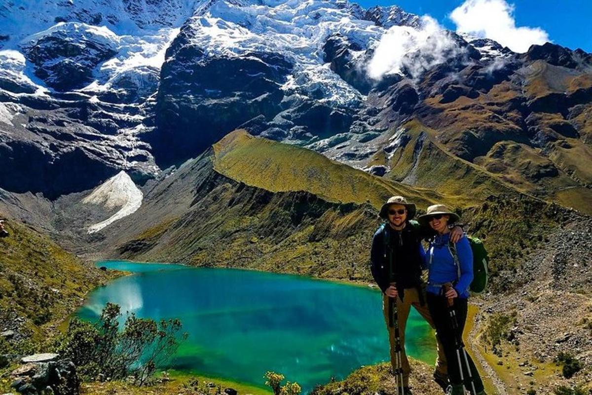 dalawang taong nakatayo sa tuktok ng bundok na may lawa