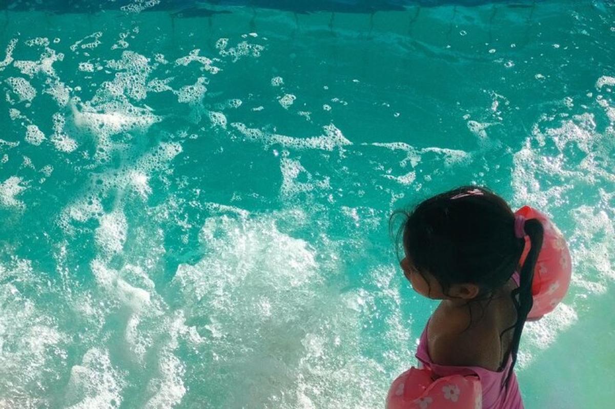 una bambina nell'acqua di una piscina