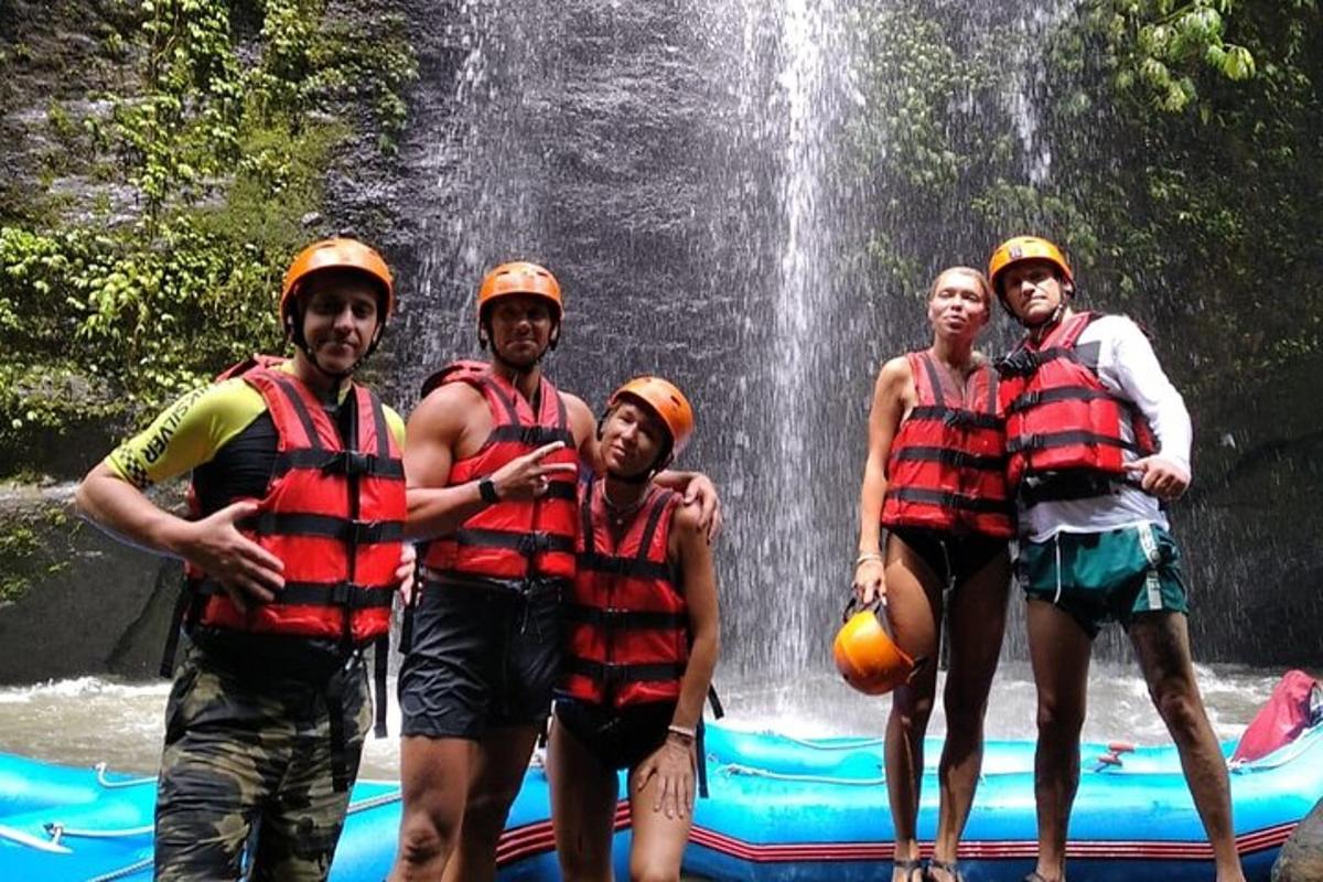 un gruppo di persone che indossano giubbotti di salvataggio in piedi davanti a una cascata