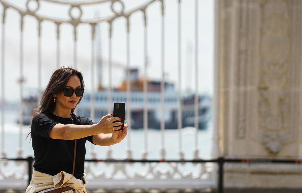 una mujer tomando una foto con su teléfono celular