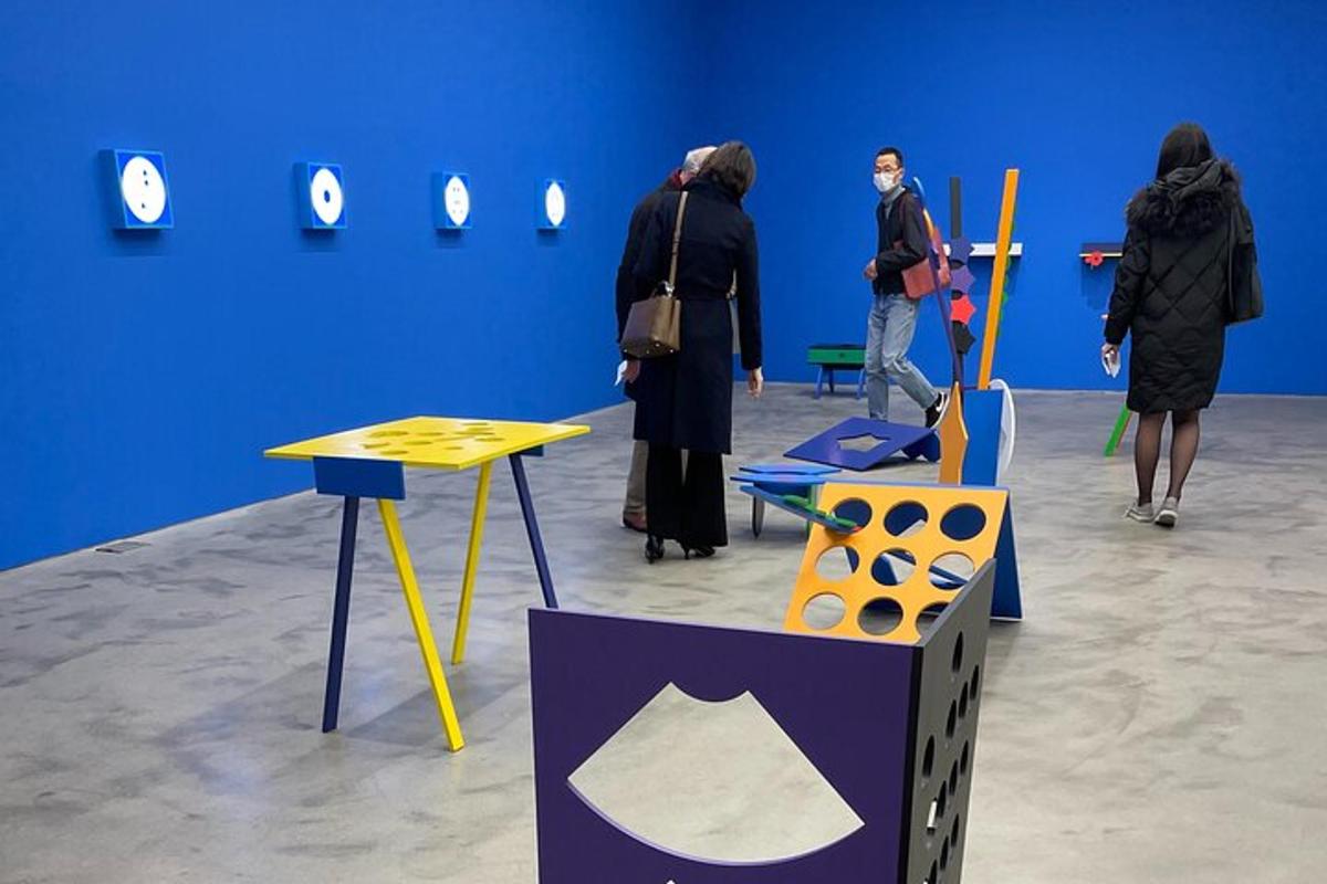 um grupo de pessoas observando exposições em uma sala