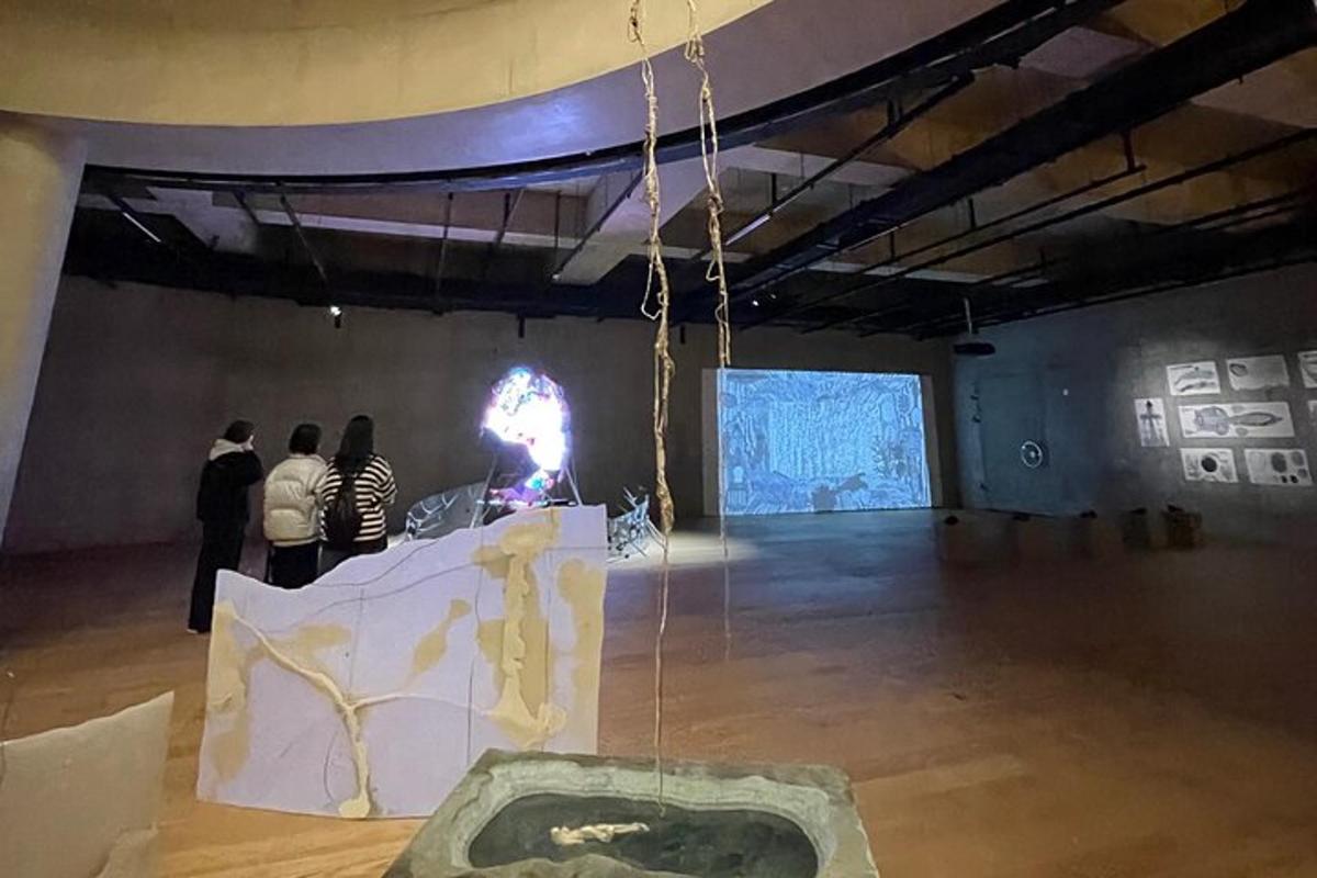 sekumpulan orang berdiri di dalam bilik besar dengan pameran