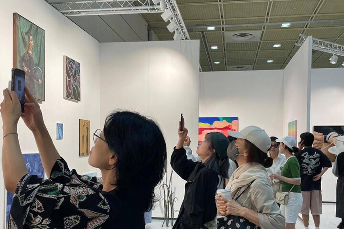 sekumpulan orang mengambil gambar lukisan di muzium