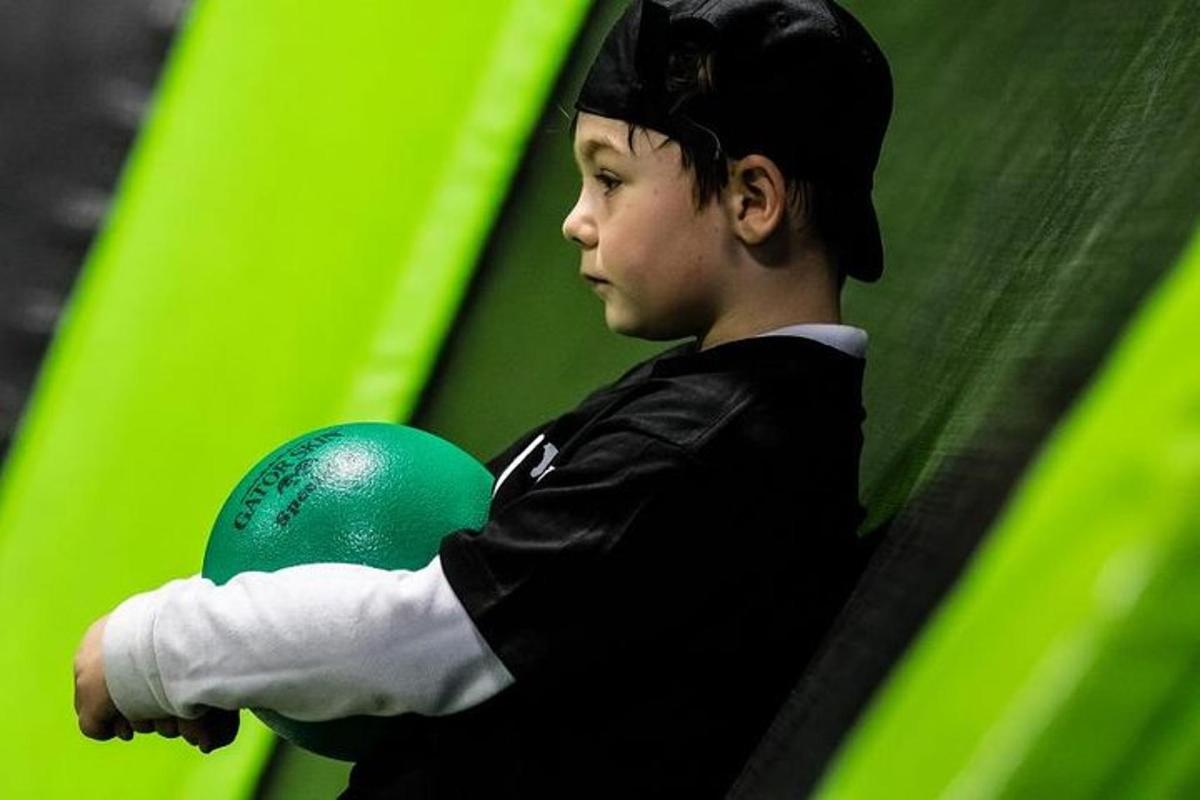Un niño pequeño sostiene una pelota verde