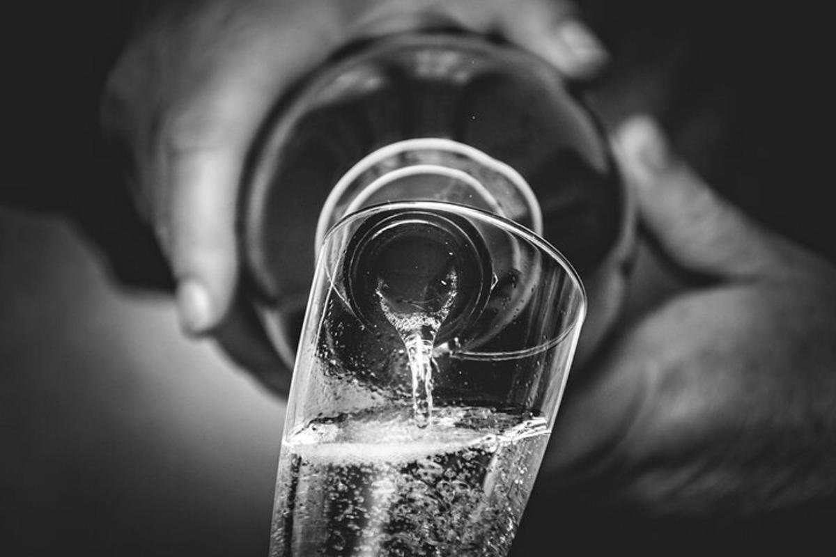 uma pessoa está bebendo de uma taça de vinho