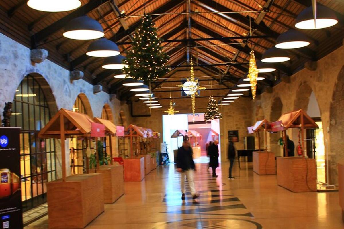 un edificio con un albero di Natale e persone che camminano in un negozio