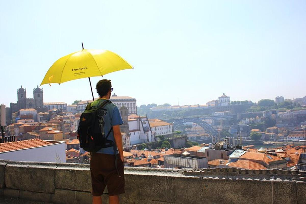 a man with a yellow umbrella looking at a city