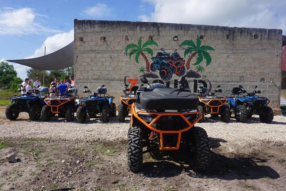 un grup de vehicles tot terreny i motocicletes aparcats al costat d'una paret