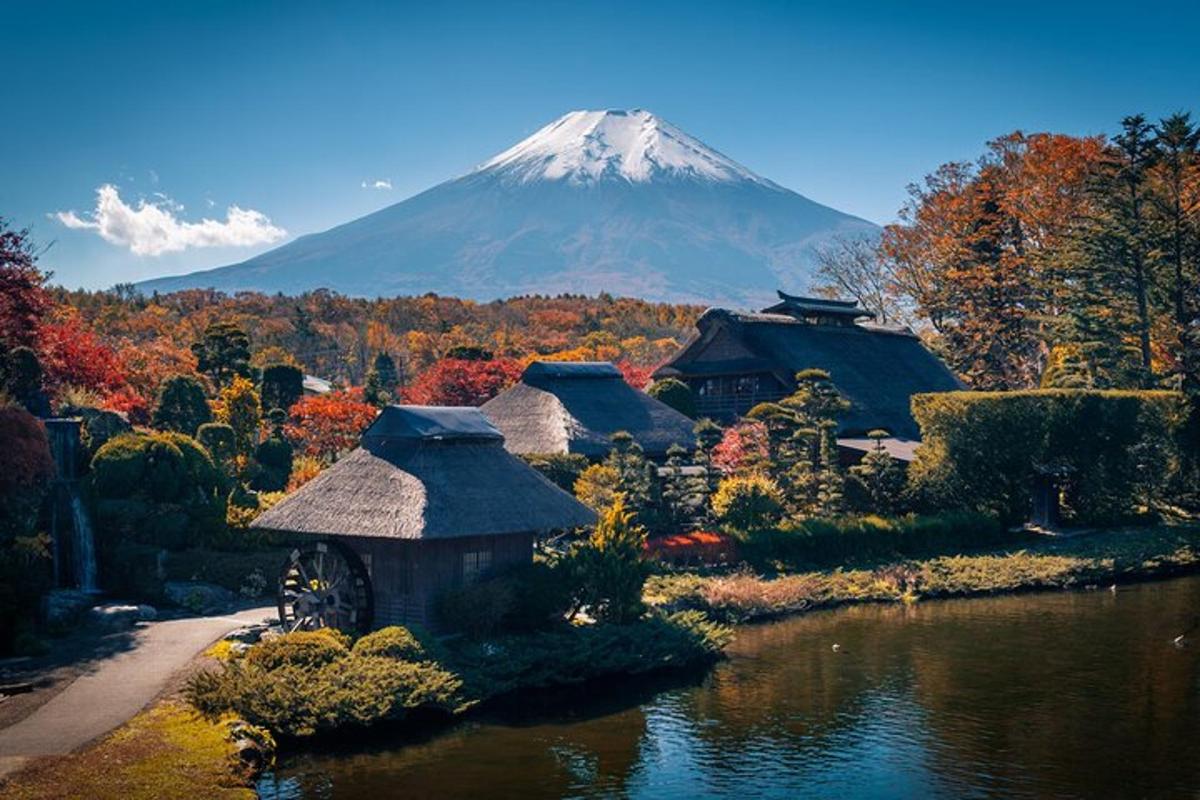 a mountain in the distance with a house and a lake