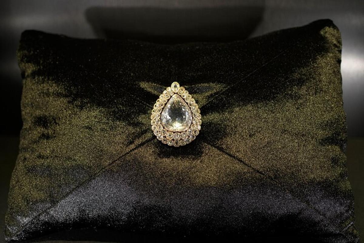 un orecchino di diamanti appoggiato su un cuscino nero