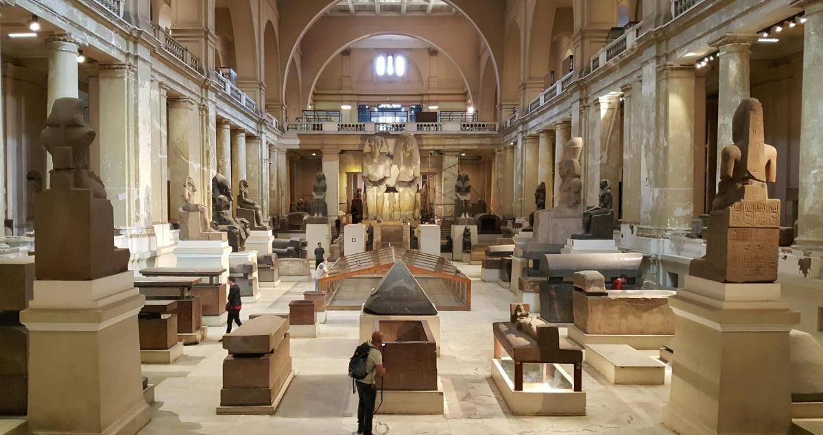 muuseum, kus inimesed seisavad suures ruumis, kus on kujud